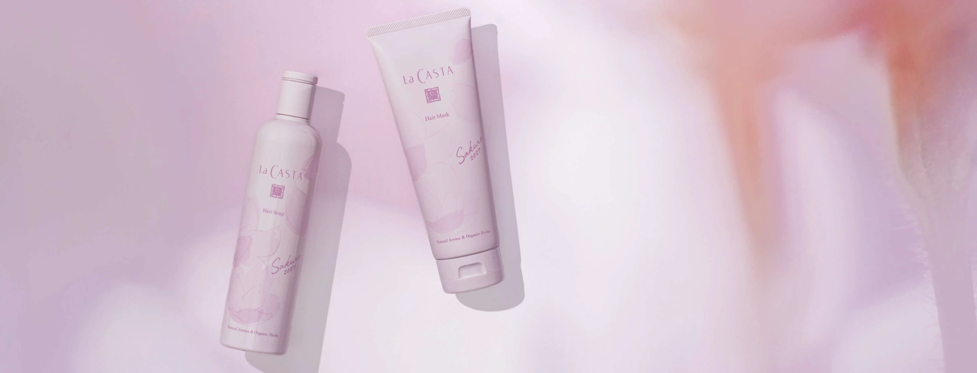 柔らかな桜色の光に浮かぶSakura 2027のヘアソープとヘアマスク